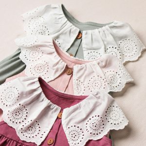 Three adorable baby dresses with lace collars in soft pastel colors. Perfect for fashion and textile enthusiasts.