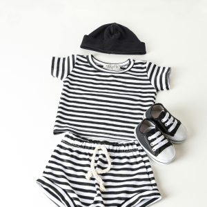 Black and white striped baby clothes set with shoes and hat in a minimalist style.